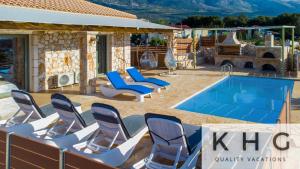 een groep stoelen en een zwembad bij Leo's Stone made Villa! in Karavádhos