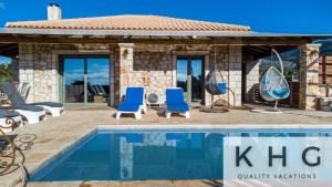 a villa with a swimming pool and blue chairs at Leo's Stone made Villa! in Karavádhos