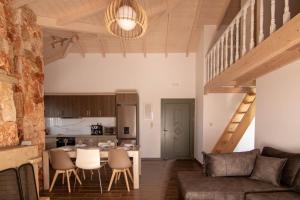 een woonkamer en een keuken met een bank en een tafel bij Leo's Stone made Villa! in Karavádhos