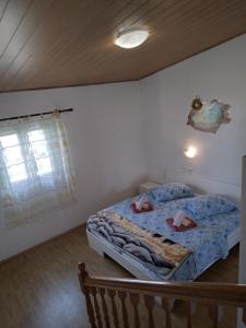 a bedroom with a bed with blue sheets and a window at Apartments "Sun-sea" in Rab