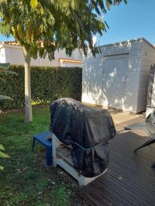 een bank met een jas erop in een tuin bij Maisonnette à deux pas de la plage dans résidence calme in La Tranche-sur-Mer