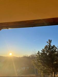 a window with a view of the sunset at Vila Xenos Loft Karakter Zlatibor in Zlatibor