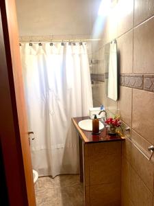 ein Badezimmer mit einem weißen Duschvorhang und einem Waschbecken in der Unterkunft Cabañas Bruma in Monte Hermoso + 35 Fotos