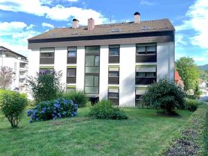 a white building with a roof on top of a yard at Moderne Ferienwohnung in bester Lage! in Bad Herrenalb