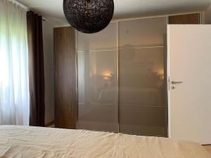 - une chambre avec un placard en verre et un lit dans l'établissement Moderne Ferienwohnung in bester Lage!, à Bad Herrenalb