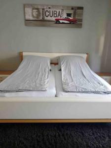 a white bed with two pillows on top of it at Moderne Ferienwohnung in bester Lage! in Bad Herrenalb