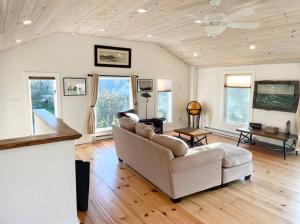 ein Wohnzimmer mit einem weißen Sofa und Holzböden in der Unterkunft Escape to Positive Outlook in Phippsburg
