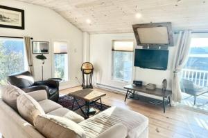 ein Wohnzimmer mit einem Sofa und einem Flachbild-TV in der Unterkunft Escape to Positive Outlook in Phippsburg