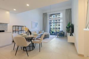 a kitchen and living room with a table and chairs at HiGuests - Charming Modern Apartment Close To The Souk in MJL in Dubai