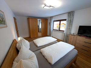 a bedroom with two beds and a flat screen tv at Apartmenthaus PARADISE in Innsbruck