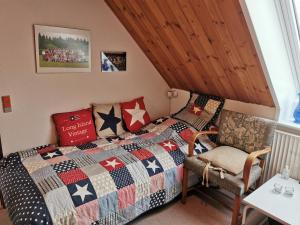 a bedroom with a bed with a quilt and a chair at Annys Bed & Breakfast in Sunds