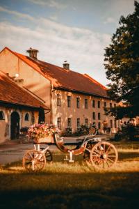 a horse drawn carriage parked in front of a building at Šlokenbekas Muiža in Milzkalne