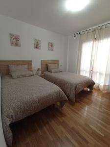 1 dormitorio con 2 camas y suelo de madera en Apartamento Centro Ciudad, en Alfaro