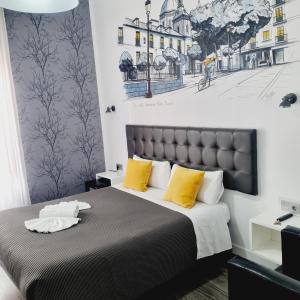 1 dormitorio con 1 cama grande con almohadas amarillas en Hostal Lauria, en Madrid