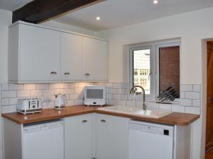 a kitchen with white cabinets and a sink at The Nook in Thirsk