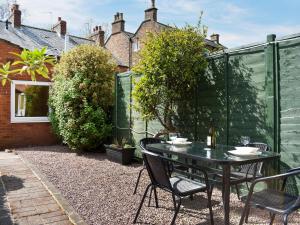 a patio with a table and chairs in a garden at The Nook in Thirsk