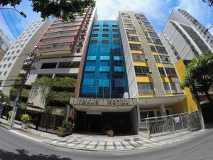 a building in a city with two tall buildings at Tower Icaraí Hotel in Niterói