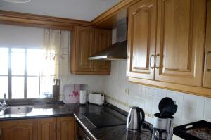 a kitchen with wooden cabinets and a sink at Villa Estrella in Tijarafe