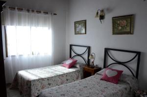 two beds with pink pillows in a bedroom at Villa Estrella in Tijarafe +2 photos
