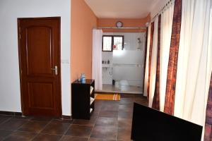 um quarto com uma casa de banho com um WC e uma porta em Studio Assiba 1 em Cotonou