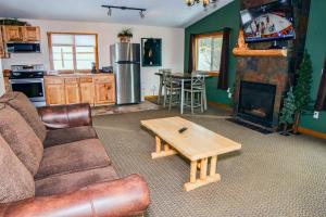 ein Wohnzimmer mit einem Sofa und einem Tisch in der Unterkunft Rocky Mountain Retreat 1B by Rocky Mountain Resorts in Estes Park