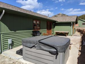ein grünes Haus mit einer Matratze davor in der Unterkunft Rocky Mountain Retreat 1B by Rocky Mountain Resorts in Estes Park