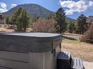 einen Whirlpool neben einer Bank mit einem Berg in der Unterkunft Rocky Mountain Retreat 1B by Rocky Mountain Resorts in Estes Park