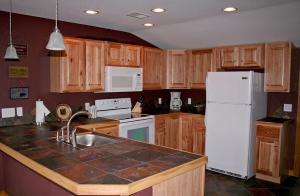 a kitchen with wooden cabinets and a white refrigerator at Rocky Mountain Retreat 2 by Rocky Mountain Resorts in Estes Park