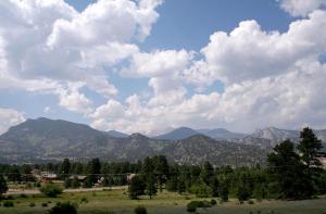 a view of a field with mountains and clouds at Rocky Mountain Retreat 2 by Rocky Mountain Resorts in Estes Park