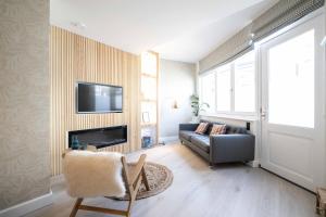 a living room with a couch and a television on a wall at Four Star Apartments - Badhuisstraat 6 in Scheveningen