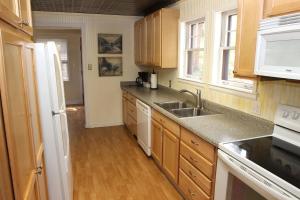 una cocina con armarios de madera y fregadero en Stonehaven Home by Rocky Mountain Resorts- #3384, en Estes Park