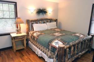 1 dormitorio con 1 cama y 1 mesa con lámpara en Stonehaven Home by Rocky Mountain Resorts- #3384, en Estes Park