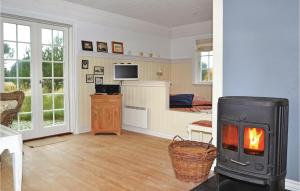 a living room with a fireplace and a bedroom at Awesome Home In Fan With 1 Bedrooms in Sønderho