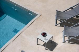 an overhead view of a pool with two chairs and a table at Sun Moon Villas, True Nature Purity, By ThinkVilla in Atsipádhes