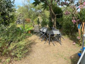 a group of chairs sitting around a table in a garden at Maison Rez de Jardin intégral entre Disney & Paris in Chelles