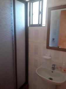 a bathroom with a sink and a mirror at Cabañas Claire in El Quisco