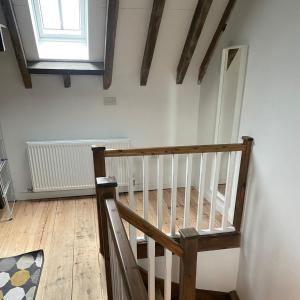 a wooden staircase in a room with a window at Loaf 3 at The Old Granary Converted Town Centre Barn in Beverley