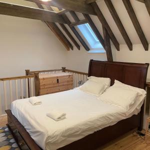 um quarto com uma cama grande com lençóis brancos e almofadas em Loaf 3 at The Old Granary Converted Town Centre Barn em Beverley