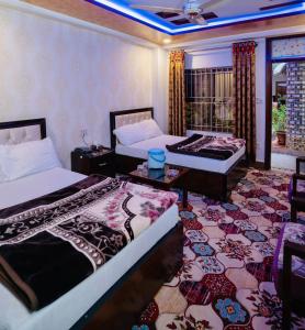 a hotel room with two beds and a balcony at Jan Luxury Hotel in Quetta
