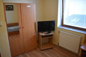 Zimmer mit TV und kleinem Tisch mit Tür in der Unterkunft Penzión Ivana in Bardejov