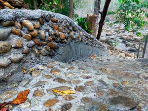 a rock wall with a water fountain on it at Huean Him Pan Homestay เฮือนฮิมปานโฮมสเตย์ in Ban Mae Pan +8 photos