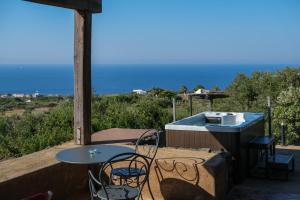 un patio con tavolo, sedie e griglia di Dammusi Al-Qubba Wellness & Resort a Pantelleria