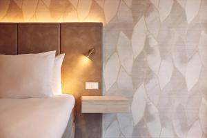 a hotel room with a bed and a nightstand with a bed sidx sidx sidx at Van der Valk Hotel Gorinchem in Gorinchem