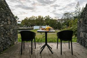 two chairs and a table with food on it on a patio at Senhora da Rosa, Tradition & Nature Hotel in Ponta Delgada