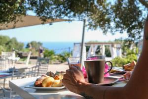 una persona seduta a un tavolo con una tazza di caffè di Dammusi Al-Qubba Wellness & Resort a Pantelleria