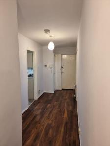 an empty room with a hallway with wood floors at Cosy 3 bed Apt/contractors/families/free parking in Birmingham