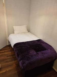 a bed in a room with a purple blanket at Cosy 3 bed Apt/contractors/families/free parking in Birmingham