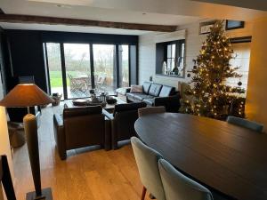 una sala de estar con un árbol de Navidad y una mesa en Country house Clos des hortensias, en Blégny