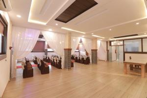 a hall with chairs and a piano in a room at OPM INN in Payyannūr
