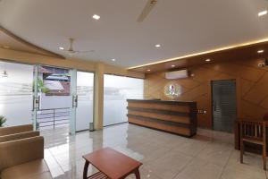 a lobby with a couch and a chair and a table at OPM INN in Payyannūr +17 photos